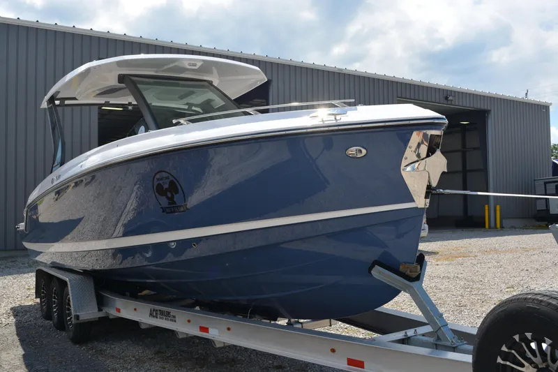 Slide: The Image of 2026 Monterey Elite 30 OB boat on trailer outside a warehouse. - 4