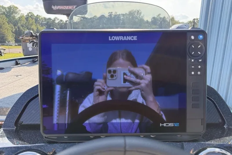 Slide: The Image of Dashboard of 2026 Phoenix 20 XE with Lowrance HDS12 display reflecting a person taking a photo. - 10