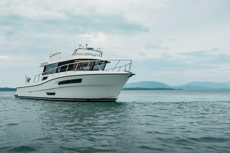 Slide: The Image of 2025 Lindell 48' yacht cruising on calm waters under cloudy skies. - 1