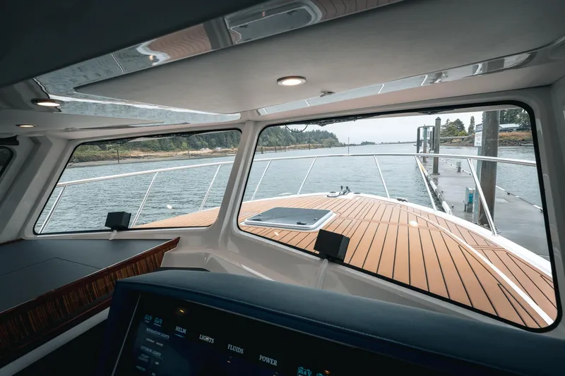Slide: The Image of Interior view from a 2025 Lindell 48' yacht, showcasing the helm and deck. - 15