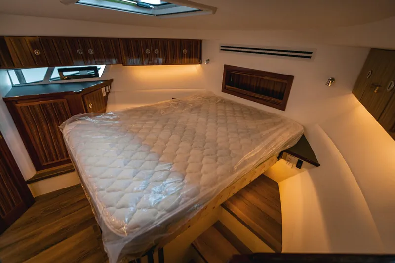 Slide: The Image of Luxurious bedroom interior of 2025 Lindell 48' yacht with cozy lighting and wood accents. - 18