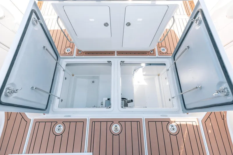 Slide: The Image of Open storage compartments on 2025 Lindell 48' boat with teak flooring. - 32