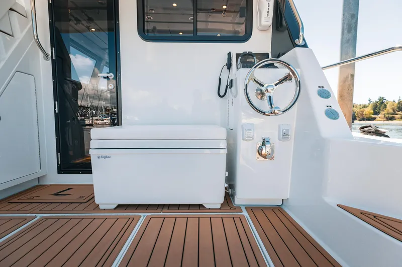 Slide: The Image of 2025 Lindell 48' yacht cockpit with teak flooring and modern steering wheel. - 37