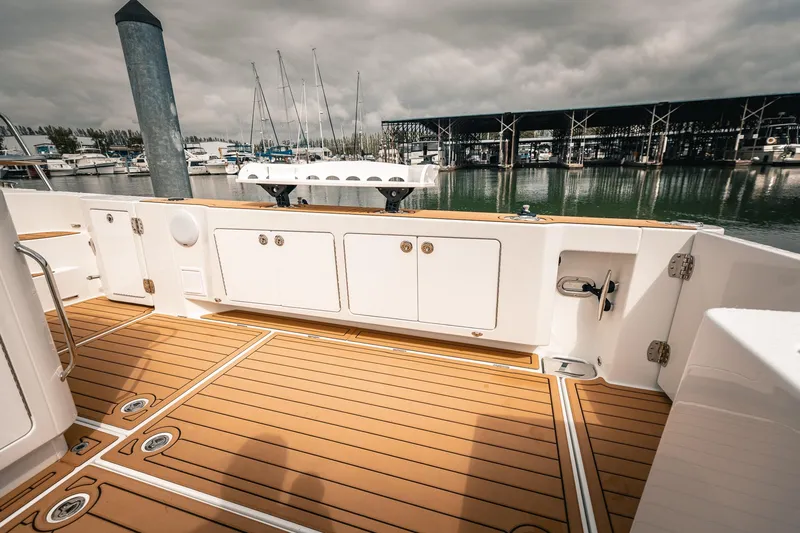 Slide: The Image of 2025 Lindell 48' yacht deck with teak flooring, docked at a marina. - 5