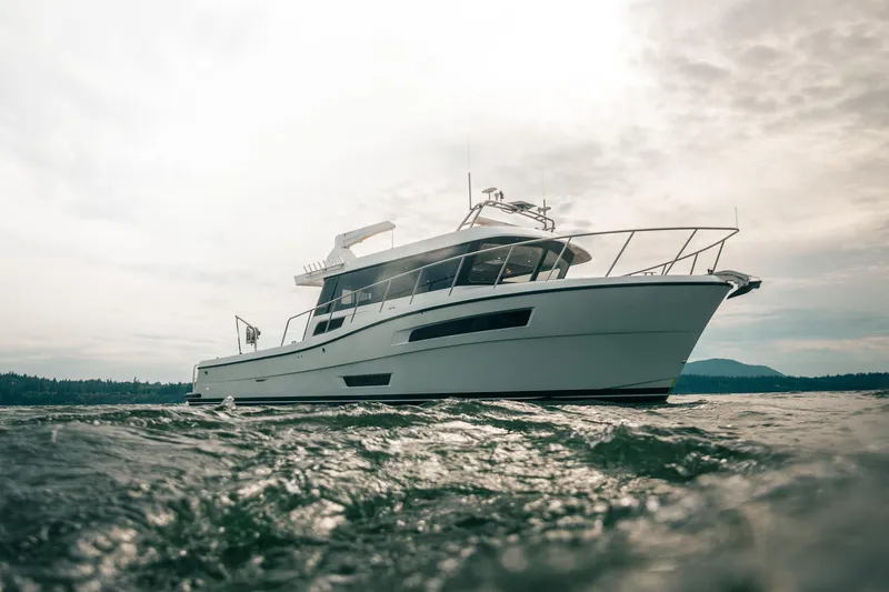 Slide: The Image of 2025 Lindell 48' yacht cruising on open water under cloudy sky. - 53