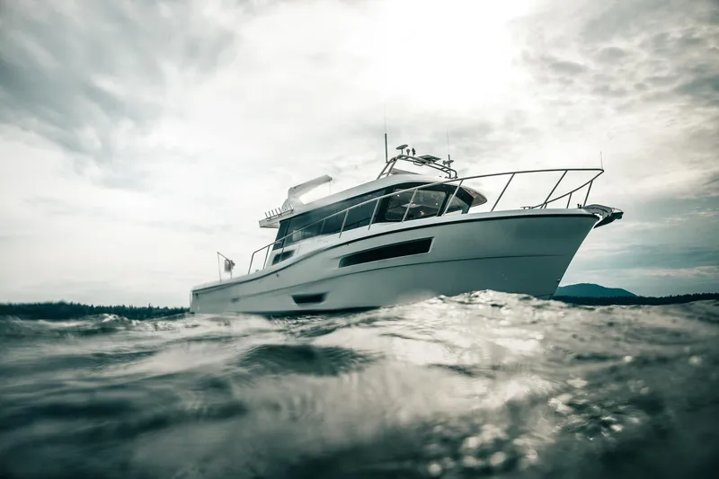 Slide: The Image of 2025 Lindell 48' yacht cruising on open water under cloudy skies. - 54