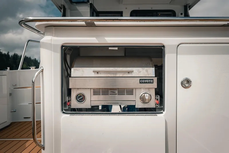 Slide: The Image of Built-in grill on 2025 Lindell 48' yacht deck, featuring Coyote brand. - 7