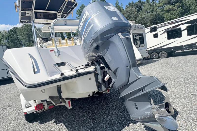 Slide: The Image of 2002 Century 2300 Center Console boat with Yamaha outboard motor, parked on gravel. - 3
