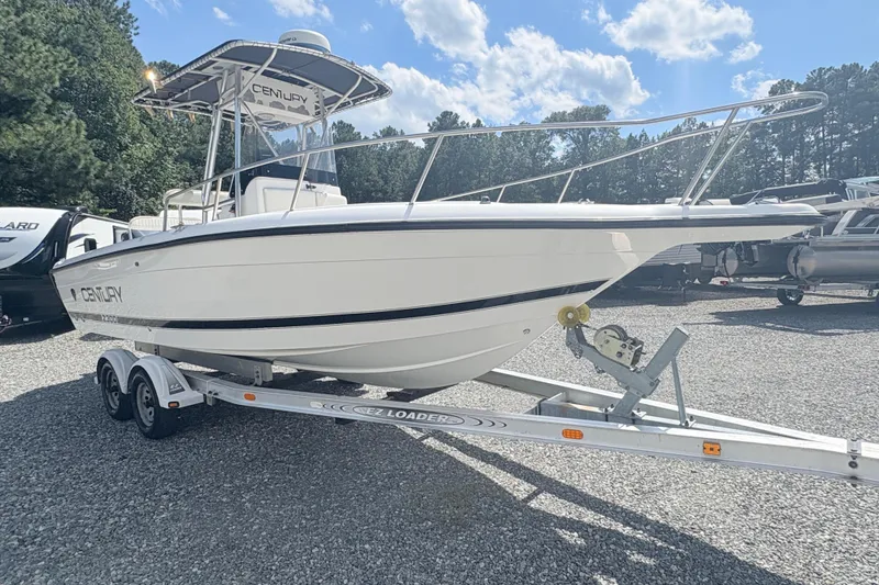 Slide: The Image of 2002 Century 2300 Center Console boat on trailer, parked outdoors under blue sky. - 5