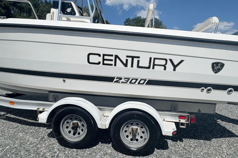 Slide: The Image of 2002 Century 2300 Center Console boat on a trailer, side view. - 7