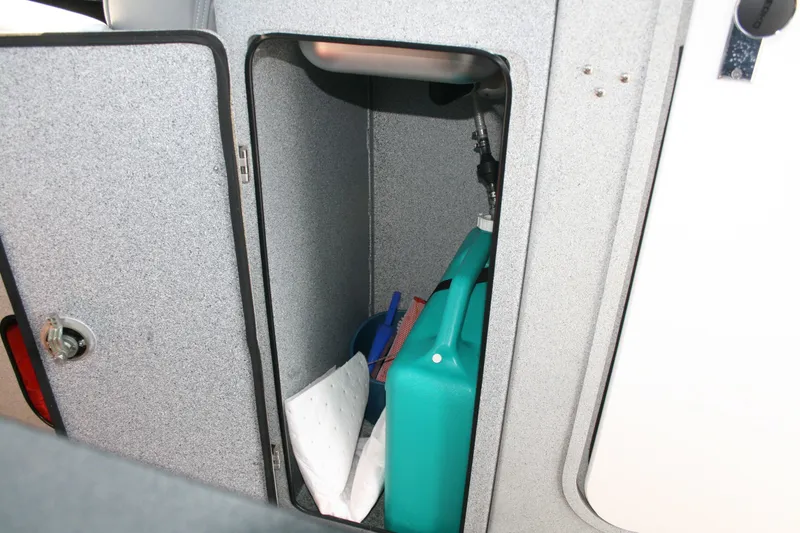 Slide: The Image of Storage compartment in a 2007 Harbercraft 2425 Pilot House boat, containing a fuel container. - 15