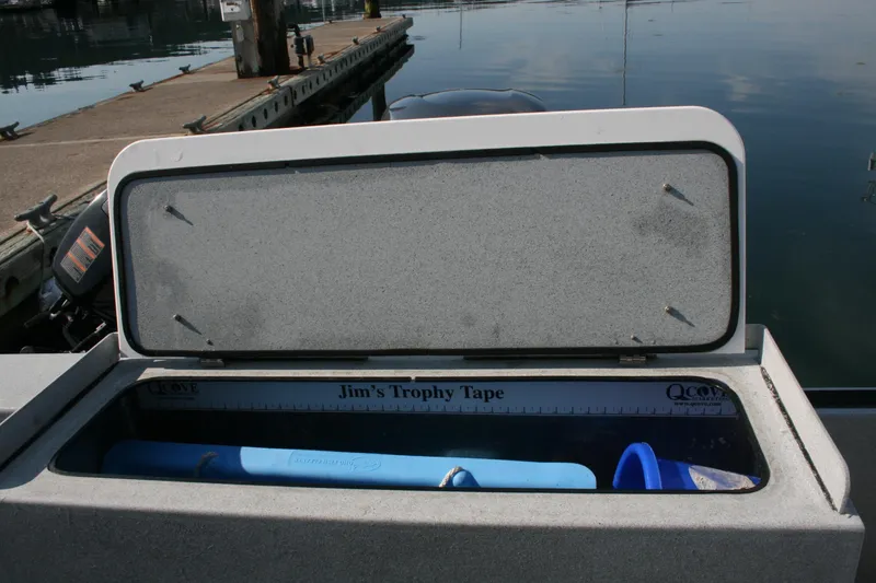 Slide: The Image of Open storage compartment on 2007 Harbercraft 2425 Pilot House boat, featuring Jim's Trophy Tape. - 16
