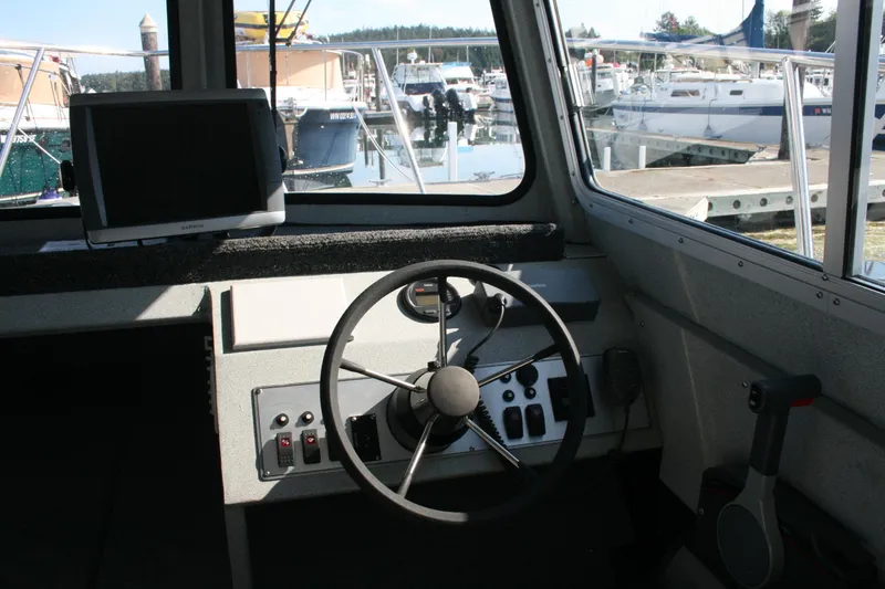 Slide: The Image of 2007 Harbercraft 2425 Pilot House interior with steering wheel and navigation equipment. - 2
