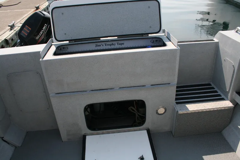 Slide: The Image of 2007 Harbercraft 2425 Pilot House boat interior with storage and Suzuki outboard motor. - 23