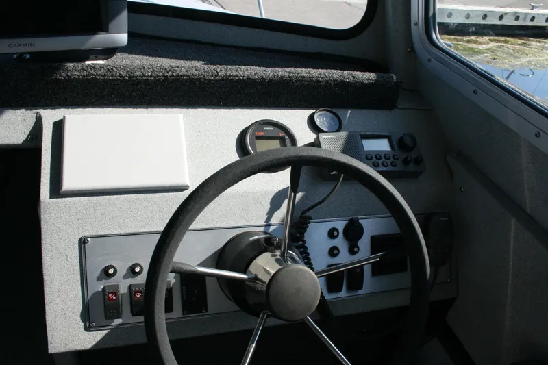 Slide: The Image of 2007 Harbercraft 2425 Pilot House boat dashboard with steering wheel and control panel. - 3