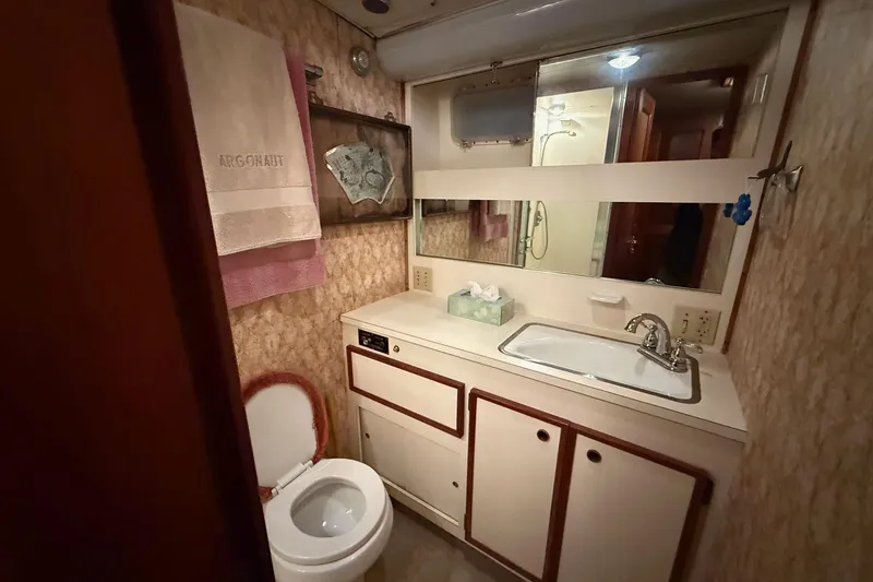 Slide: The Image of 1980 Hatteras 42 LRC yacht kitchen with wooden cabinets and striped flooring. - 10