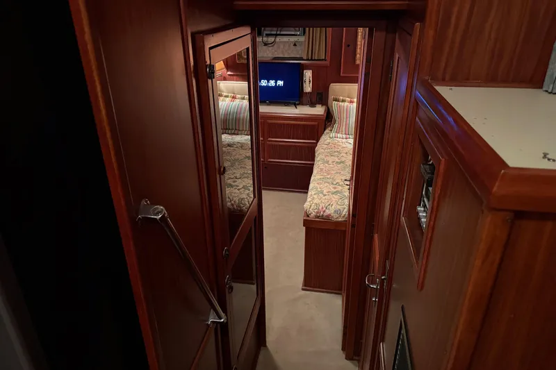 Slide: The Image of 1980 Hatteras 42 LRC cabin interior with twin beds, wood paneling, and cozy decor. - 14