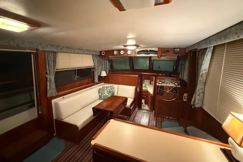 Slide: The Image of Interior of 1980 Hatteras 42 LRC yacht with cozy seating and wooden accents. - 22