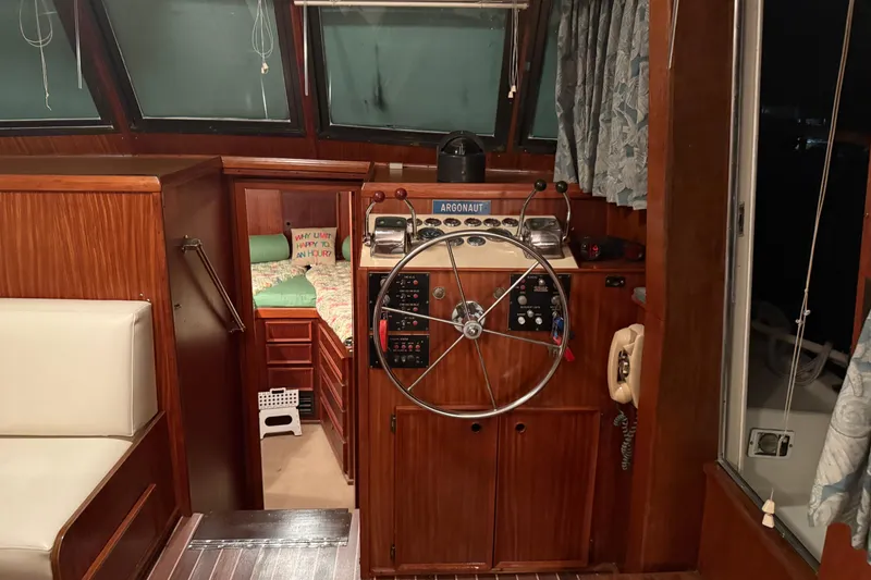 Slide: The Image of 1980 Hatteras 42 LRC yacht interior with helm, wooden finish, and cozy cabin view. - 23