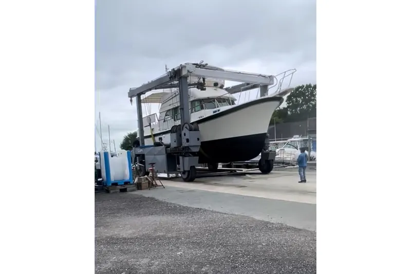 Slide: The Image of 1980 Hatteras 42 LRC yacht on a lift at a marina, overcast sky. - 28