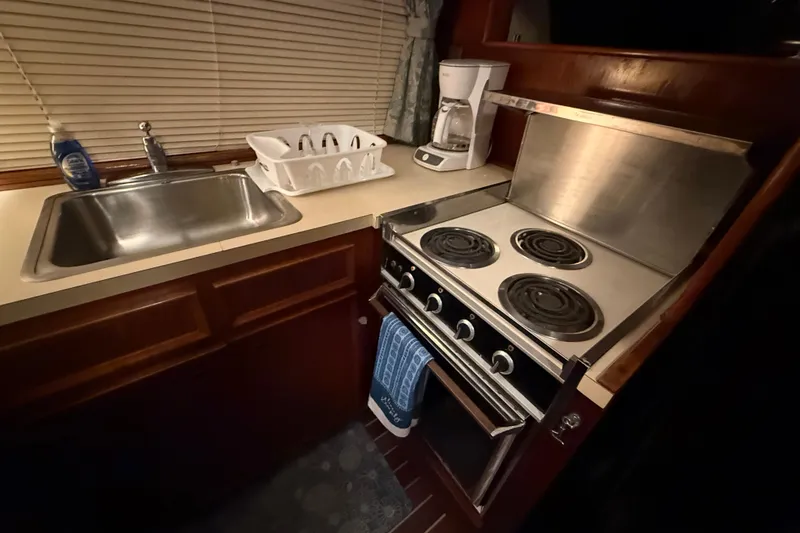 Slide: The Image of Compact kitchen in a 1980 Hatteras 42 LRC yacht with stove and sink. - 37