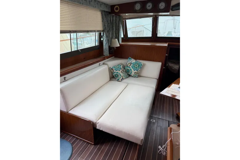 Slide: The Image of Interior of 1980 Hatteras 42 LRC yacht with white seating and decorative pillows. - 44