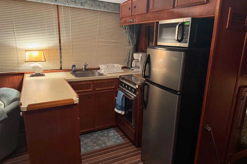 Slide: The Image of 1980 Hatteras 42 LRC yacht kitchen with modern appliances and wood cabinetry. - 6