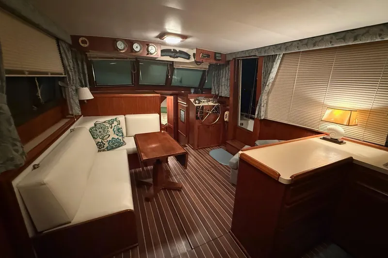 Slide: The Image of Interior of 1980 Hatteras 42 LRC yacht with cozy seating and nautical decor. - 7