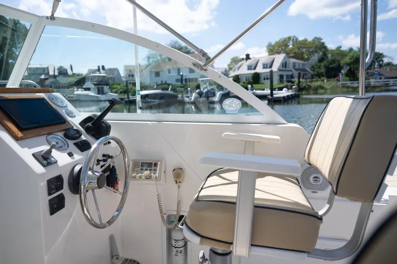 Slide: The Image of 2004 Hunt Yachts Surfhunter 25 helm with steering wheel and controls, dockside view. - 15