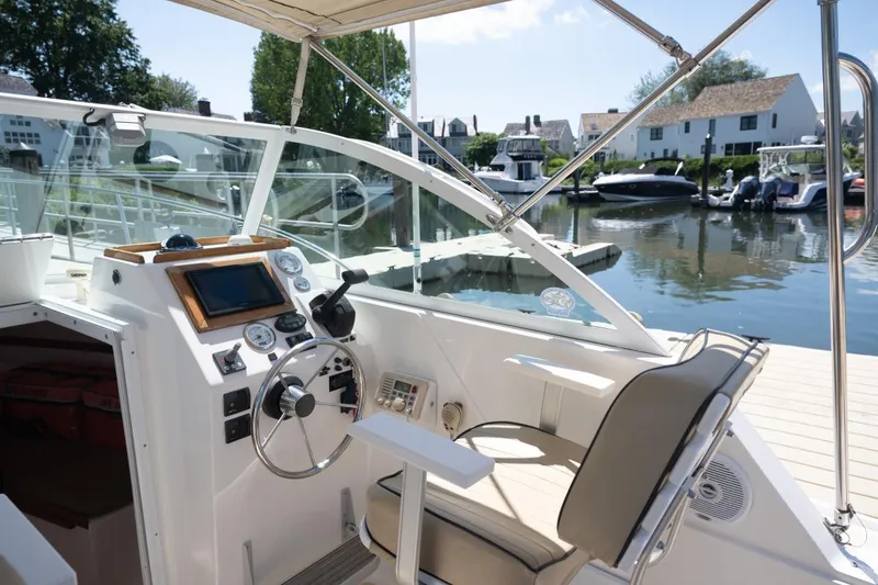 Slide: The Image of 2004 Hunt Yachts Surfhunter 25 helm with steering wheel, gauges, and waterfront view. - 17