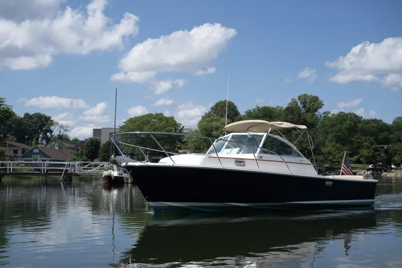 Slide: The Image of 2004 Hunt Yachts Surfhunter 25 on calm water under a clear blue sky. - 2
