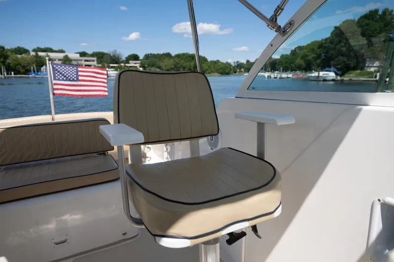 Slide: The Image of 2004 Hunt Yachts Surfhunter 25 interior with seating and American flag on a sunny day. - 20