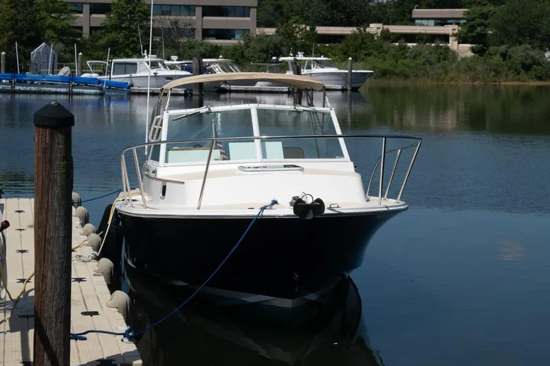 Slide: The Image of 2004 Hunt Yachts Surfhunter 25 docked in a serene marina setting. - 3