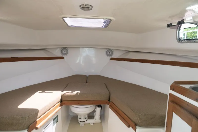 Slide: The Image of Interior cabin of 2004 Hunt Yachts Surfhunter 25 with cushioned seating and wooden accents. - 30