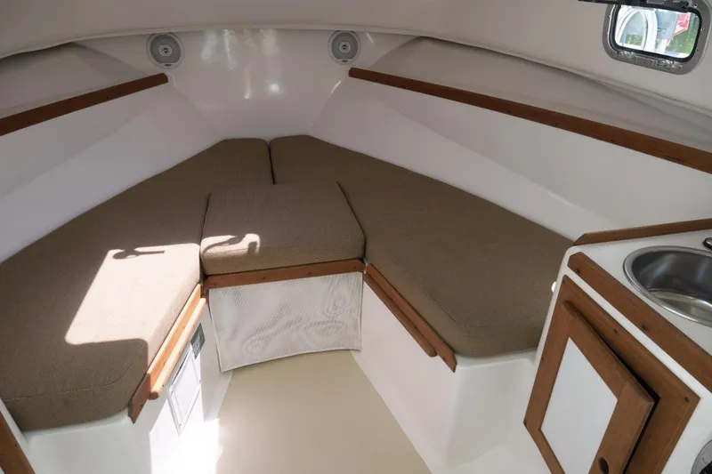 Slide: The Image of 2004 Hunt Yachts Surfhunter 25 cabin interior with cushioned seating and compact sink area. - 31