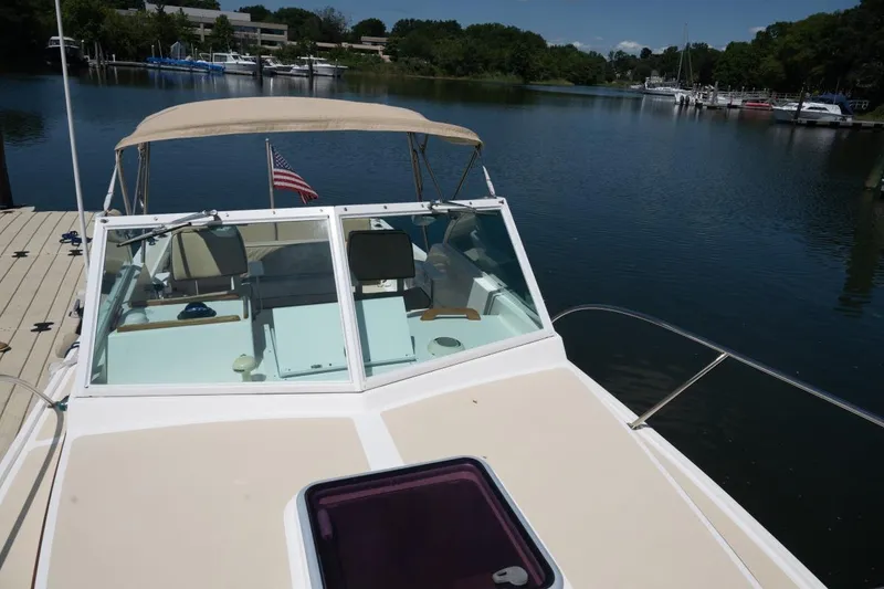 Slide: The Image of 2004 Hunt Yachts Surfhunter 25 docked on a serene lake with American flag. - 38
