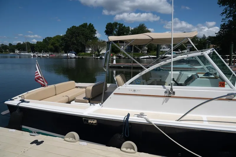 Slide: The Image of 2004 Hunt Yachts Surfhunter 25 docked by a serene lake under a blue sky. - 4