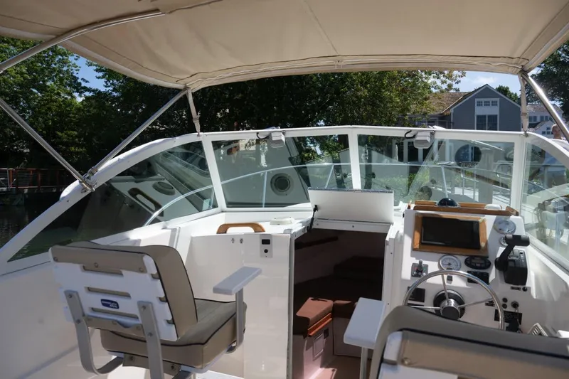 Slide: The Image of 2004 Hunt Yachts Surfhunter 25 interior with helm, seating, and canopy. - 21
