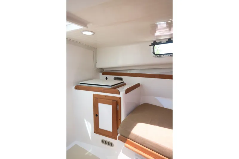 Slide: The Image of 2004 Hunt Yachts Surfhunter 25 cabin interior with wooden accents and seating. - 25