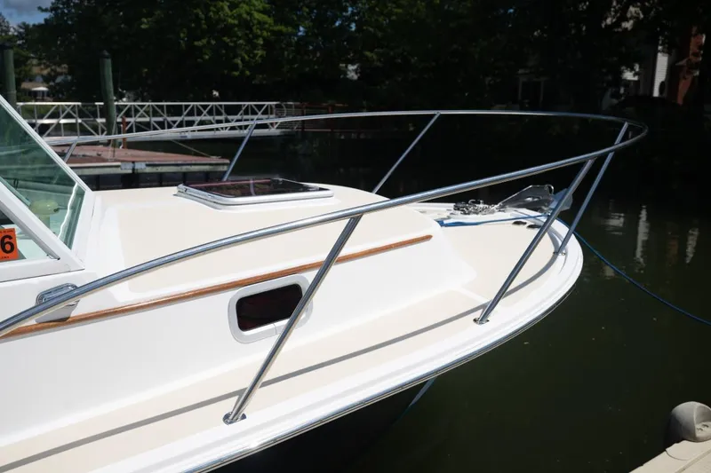 Slide: The Image of 2004 Hunt Yachts Surfhunter 25 boat docked, featuring sleek design and stainless steel railings. - 40