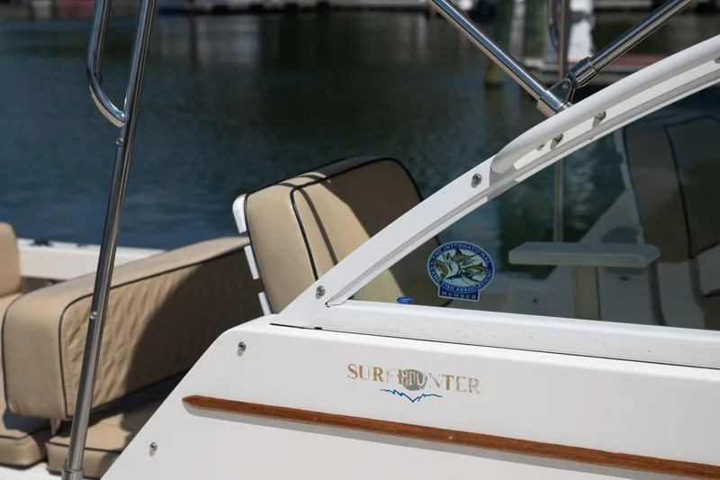 Slide: The Image of 2004 Hunt Yachts Surfhunter 25 boat with beige seating, docked by the water. - 41