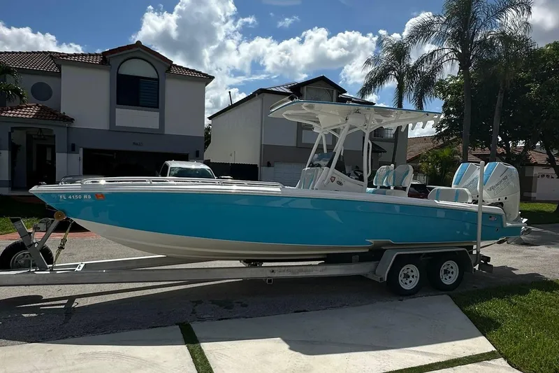 The Image of 2019 Concept 27' CC boat on trailer, parked in residential area under clear sky. - 0