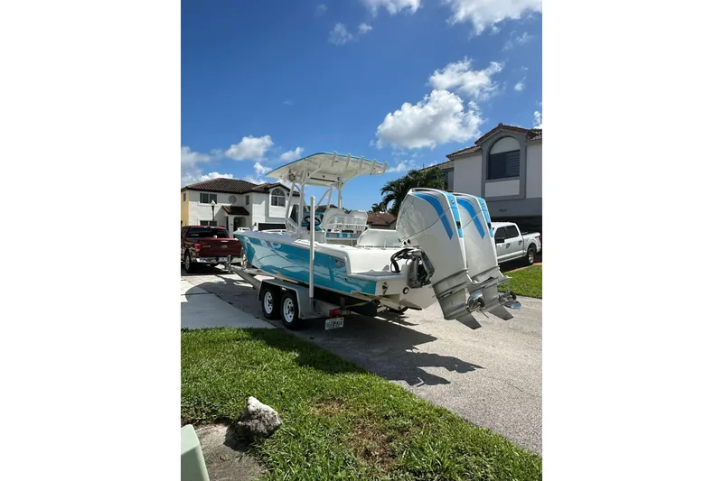 Slide: The Image of 2019 Concept 27' CC boat on trailer, parked in residential driveway under blue sky. - 10