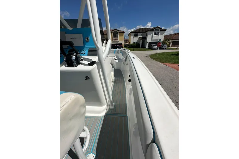 Slide: The Image of 2019 Concept 27' CC boat interior with white and blue accents, parked in a residential area. - 19