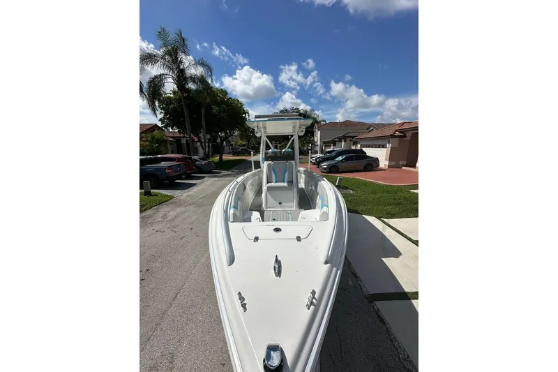 Slide: The Image of 2019 Concept 27' CC boat parked on a residential street under a clear blue sky. - 2