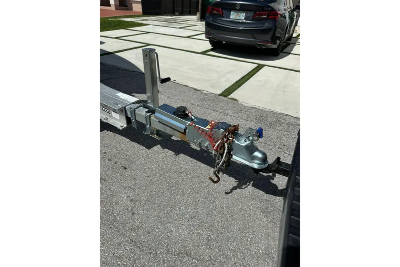 Slide: The Image of Trailer hitch of a 2019 Concept 27' CC on a driveway, with safety chains attached. - 22