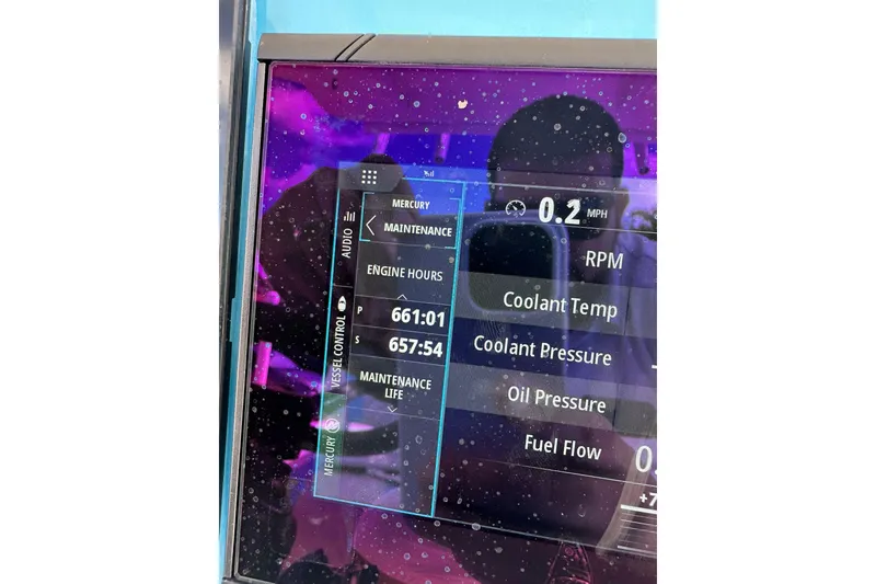 Slide: The Image of Close-up of a 2019 Concept 27' CC boat's digital dashboard displaying engine metrics. - 27