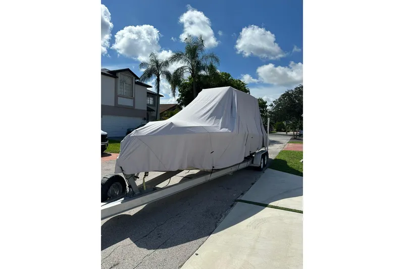 Slide: The Image of Covered 2019 Concept 27' CC boat on trailer in residential driveway. - 3