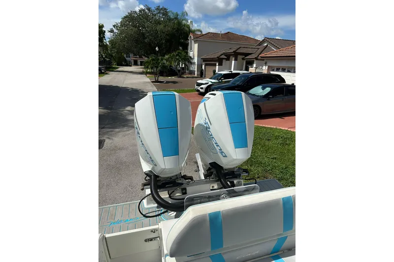 Slide: The Image of Twin outboard motors on a 2019 Concept 27' CC boat, parked in a residential area. - 6