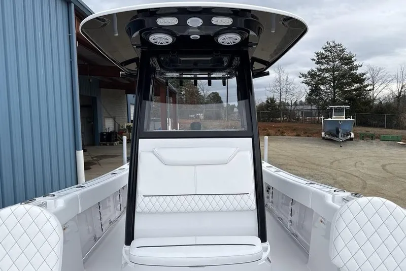 Slide: The Image of 2026 Sportsman Heritage 231 Center Console boat with sleek white seating and modern design. - 11